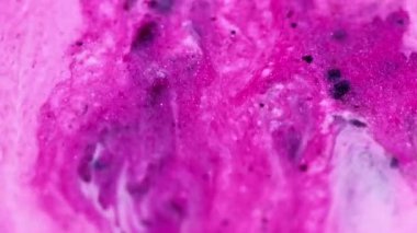 Parlak boya. Mürekkep akışı. Parlak parıltı. Odaklanmamış pembe beyaz renk parıltılı sıvı sızıntısı büyüleyici kozmetik sıvısı ışkan parçacıklar hareketli soyut sanat arka planı.
