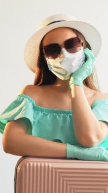 Dikey video. Salgın sıkıldı. Coronavirus yoruldu. Hayal kırıklığına uğramış kız maske eldivenleriyle hayal kırıklığına uğradı ve yaz tatili dinlenmesi için beyaz eldivenleri bekledi..