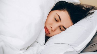 Sabah erkenden. Uyuyan kadın. Yorgun bir gün. Yorgun kadın gözleri yumuşak beyaz yatakta battaniyenin altında uzanır..