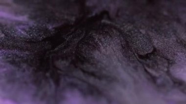 Parlak mürekkep. Parlak arka plan sıvı akışı. Sihirli mor siyah parıldayan parçacıklar soyut sanat dokusunu yayıyor..