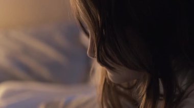 Gece video oyunu. Çocuklar için boş zaman. Dijital medya. Yatma vakti. Küçük kız yatmadan önce cep telefonuyla oynuyor. Karanlık bir yatak odasında, sıcak bir lambayla..