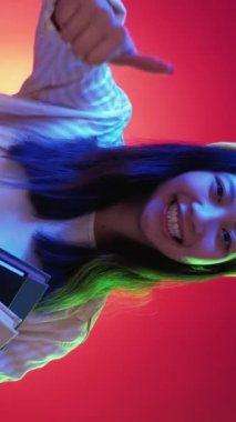 Eğitim tavsiye edilir. Öğrenim onayı. Mutlu, mutlu, gülümseyen kadın öğrenci kitaplara işaret ediyor. Kırmızı, mavi, neon ışıklı bir jest gibi parmakla işaret ediyor..