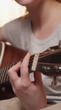 Dikey video. Gitar keyfi. Şarkı söyleme hobisi. Müzik ilhamı. Yetenekli vokalist kadın akustik telli enstrümanla şarkı çalmaktan hoşlanıyor..