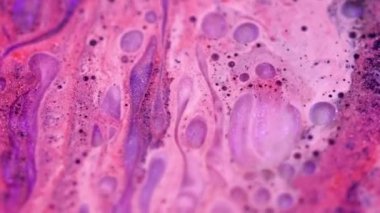 Boya damlası. Parıldayan mürekkep. Kabarcık dokusu. Odaklanmamış mor siyah renk dökülmüş, köpüklü sıvı su damlası hareket soyut sanat arka planı.