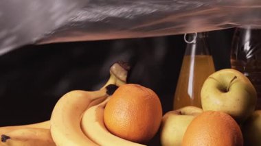 Plastik kirliliği. Doğa koruma. Ekoloji koruması. Dünyayı kaplayan polietilen film koyu renkli taze organik meyve kompozisyonu ile.