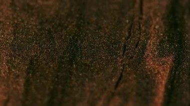 Parıltı emülsiyonu. Boya akışı. Odaklanamayan parlak bronzlaşmış siyah renkli sıvı dokusu soyut arkaplan hareket parçacıkları.