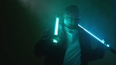 Rapçi performansı. Gece kulübü şovu. Kendine güvenen, stil sahibi, hip hop müzisyeni. Parlak neon lambalı sanatçı. Geceleyin dumanlı arka plan fotokopi alanında..