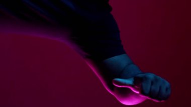 Dikey video. Nefret dolu bir jest. Olumsuz görüş. Hayal kırıklığına uğramış, kuşkucu, kuşkucu, suratında yüz ifadesi olmayan burgundy arka planında baş parmak işareti olan mutsuz bir adam..