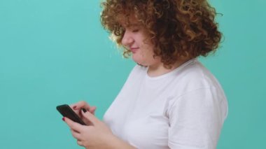 İnternet bağımlılığı. Sosyal medya. Mavi kopya arkaplanda izole edilmiş telefon kullanmak gibi mesajlar atan tombul kız..