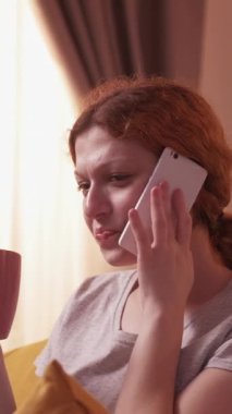 Dikey video. Telefon var. İçki muhabbeti. Rahatlamış gülüşler kızıl saçlı kadın cihaz başını tut. İnternetten iletişim kur. İçki iç, kahve iç..