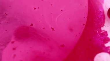 Lüks boya. Işıldayan sıvı. Kabarcık dokusu. Odaklanmamış pembe beyaz renk yağ damlaları ve soyut sanat arkaplanı ile parlayan jel..