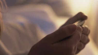 Çocuk evde boş zaman. Gadget kullanımı. Sosyal medya. Yatma vakti. Akıllı, uykulu, küçük kız yatak odasında cep telefonuyla çizgi film izliyor..