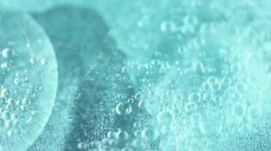 Yağlı su karışımı. Köpük sıvısı. Odaklanmamış açık mavi renk sıvısı girdap ıslak parlaklık dokusu sarmal emülsiyon soyut sanat arka planı.