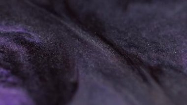 Parıltı akıyor. Mürekkep emülsiyonu. Mor lavanta rengini karıştıran koyu, çözünmüş, köpüklü sıvı. Parıldayan parçacıklar, boya karışımı doku arka planı..