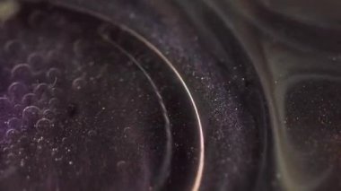 Köpüklü sıvı. Lüks mürekkep. Odaklanamayan siyah altın rengi karıştıran sim parçacıkları etrafa saçılan ışıltılı boya yüzen yağ kabarcıkları hareket eden soyut sanat arka planı.