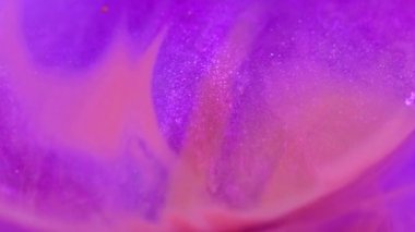 Neon mürekkebi. Parıltılı boya. Odaklanmamış mor turuncu renk kıvrımlı parlak jel parlak sis parıldayan emülsiyon hareketi soyut sanat arka planı