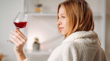 Şarap gevşetir. Olumlu duygular. Manikürlü, mutlu, huzurlu bir kadın. Spa işleminden sonra elinde kırmızı bardakla eğleniyor..