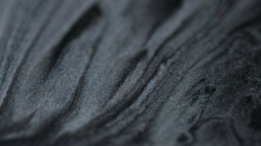 Jel sıvıları. Parıldayan maddeler. Yapışkan bir yapı. Odaklanmamış siyah gümüş rengi parıldıyor pullar desen boya sıvısı soyut sanat arka planı.
