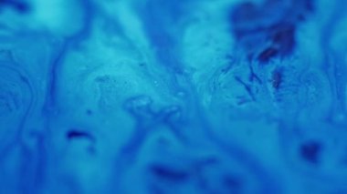 Sıvı dökülmesi. Akrilik sıvı. Odaklanmamış mavi renk boyalı su emülsiyon akışı hareket yaratıcı soyut sanat arkaplanı yayıyor.