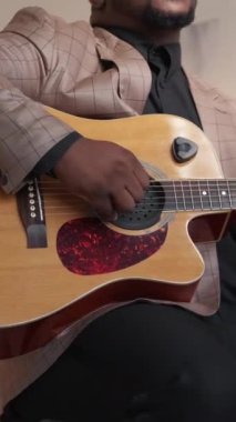 Dikey video. Gitarist. Müzisyen yaşam tarzı. Şarkı alıştırması. Evde akustik telli enstrümanla şarkı söyleyen tanınmamış yetenekli bir adam..