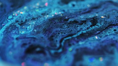 Kabarcık boya dokusu. Köpüklü sıvı akışı. Bulanık mavi renkli parlak parçacıklar ıslak köpük su pigmenti mürekkep karışımı soyut sanat arka planı.