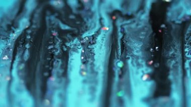 Parlak bir dökülme. Akrilik boya. Odaklanmamış mavi renkli holografik simli parçacıklar yüzen baloncuklar boya sıvı karışımı akış hareketi soyut sanat arka planı.