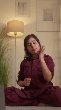 Dikey video. Yoga vlogu. İnternet çalışması. Spor saadeti. Kadın sanal koç blogcu ev oturma odasında dizüstü bilgisayarda Mudra pozu öğretiyor..