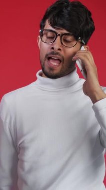 Dikey video. Mobil tartışma. Rahatsız edici bir arama. Olumsuz iletişim. Öfkeli, sinirli, sinirli, kırmızı ışıkta izole bir şekilde telefonla bağıran adam..