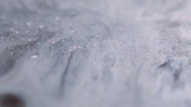 Parçacık mürekkebi. Sıvı dökülmesi. Odaklanmamış gri renk emülsiyon dokusu akrilik sıvı akış hareketi soyut sanat arkaplanı.