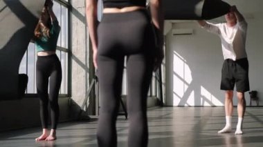 Yoga insanları. Jimnastik dersi. Spor salonundaki spor salonunda çıplak ayakla antrenman yapmadan önce spor minderi açıyorlar..