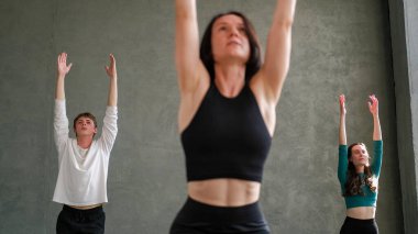 Spor grubu. Yoga eğitimi. Spor salonundaki bayan spor koçuyla egzersiz dengesi kursuna uygun insanlar..