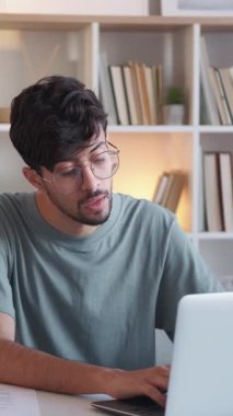 Dikey video. İnternet işi. Uzaktan kumandalı. İnternet araştırması. Modern iş yerinde bilgisayarla çalışan düşünceli, zeki bir adam..
