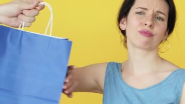 Reddedilen hediye. Rüya hediyesi. İstenmeyen mavi paketi reddeden ve mutlu olan kadın pembe kağıt torbayı kabul ediyor..