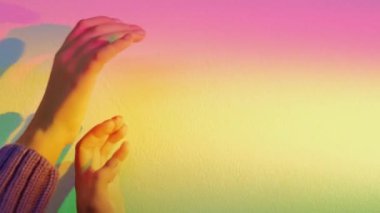 Gün ışığı elleri. Işığa ulaşıyor. Meditasyon enerjisi. Zarif kadın kolları, bulanık renkte, gökkuşağı renginde, arkaplanı boş, güneş ışığı renginde hareket ediyor..