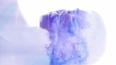 Dikey video. Fantezi portresi. Ruhsal aura. Mavi mor sis kadın siluetini dolduruyor. Beyaz arkaplanda çift pozlama izole edilmiş..