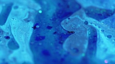 Köpüklü sıvı. Parlak yağ damlası. Odaklanmamış mavi renk parlak tahıl parçacıkları su boyası sıvı pigment emülsiyon hareket soyut sanat arka planı.