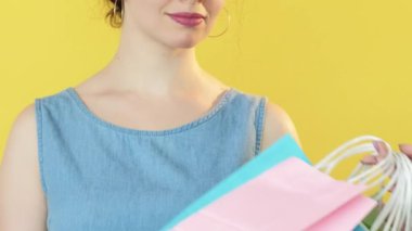 Alışveriş fiyaskosu. Üzgün müşteri. Alışverişkolik kadın, sarı boş alan arka planında izole edilmiş başka bir alıcıya kese kâğıtlarını kaybetmekten bıktı..