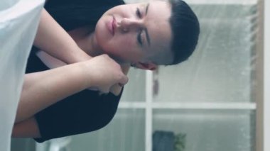 Dikey video. Depresyon izolasyonu. Üzücü bir acı. Nostaljik aşırı kilolu kadın kötü bir ruh hali içinde iç çekiyor ellerini katlıyor oturma odasını kopyalıyor..