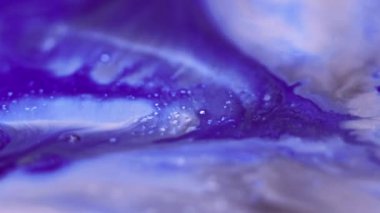 Parlak mürekkep sıçraması. Sıvı dökülmesi. Odaklanmamış mavi renk tahıl dokusu akrilik sıvı karışım damla dalga hareketi soyut sanat arkaplanı.