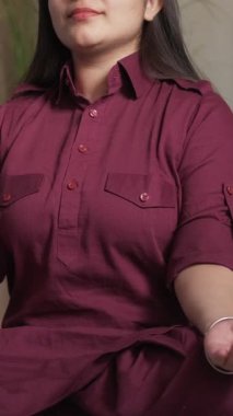 Dikey video. Meditasyon sabahı. Yoga pratiği. Sağlıklı bir yaşam tarzı. Nilüferde oturan sakin ruhlu kadın evde dhyana mahamayuri mudra hareketi yapıyor..