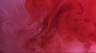 Duman püskürtüyor. Suyun altına çek. Odaklanamayan parlak kırmızı beyaz, modern sanatın soyut arka planında dönen pigment mürekkebini zıtlaştırır.