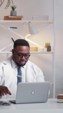 Dikey video. Radyografi uzmanı. Tıbbi uzmanlık. Sağlık uzmanıyım. Şok olmuş doktor doktor. Bilgisayarda röntgen inceleniyor. Hastanenin çalışma alanından arıyorlar..