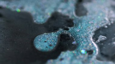 Sıvı sim dökülmüş. Mürekkep sıvısı. Bulanık deniz mavisi siyah holografik parçacıklar boya damlaları emülsiyon jel damla soyut sanat arka planı ile bokeh ışıkları.