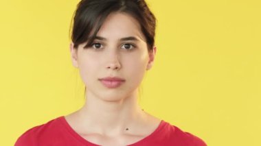 Neşeli bir ifade. İşaret parmağı. Heyecanlı mutlu kadın sarı arka planda izole edilmiş boş alana işaret ediyor..