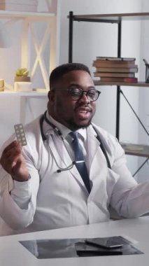 Dikey video. Tıbbi danışmanlık. Farmakolojik terapi. Mutlu adam sağlık doktoru hastane çalışma alanında ilaç tedavisi öneriyor. Ağrı kesici haplar..