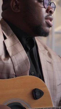 Dikey video. Erkek şarkıcı. Yetenekli bir sanatçı. Gitar keyfi. Saygıdeğer müzisyen, akustik telli enstrüman ile evde şarkı çalma konusunda ilham kaynağı oldu..