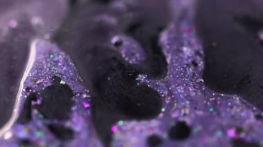 Parlak mürekkep damlası. Parlak sıvı doku. Bulanık mor renkli yanardöner pullar yağ boyası sıvısı dökülmesi soyut sanat arka planında Bokeh ışıkları.