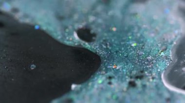 Parlak mürekkep damlası. Boya dökülmüş. Bulanık mavi renkli holografik pullar yağ parıldayan jel sıvısı emülsiyon sızıntısı soyut sanat arka planı ve Bokeh ışıkları.