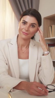 Dikey video. Çevrimiçi toplantı. Şüpheci kadın. Meslektaşlar rapor veriyor. Video konferansı yapan kadını suçlamak ofis içi aydınlatma odasında oturmaktan sıkılmak.