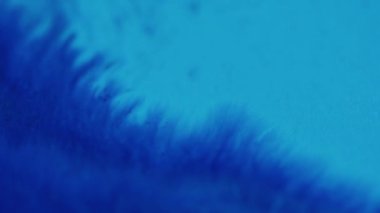 Parlayan sıvı. Yapışkan damlalar. Parlak mürekkep dokusu. Odaklanmamış parlak mavi renk parıldayan boya karışımı dalga hareketinin soyut sanat arkaplanı.